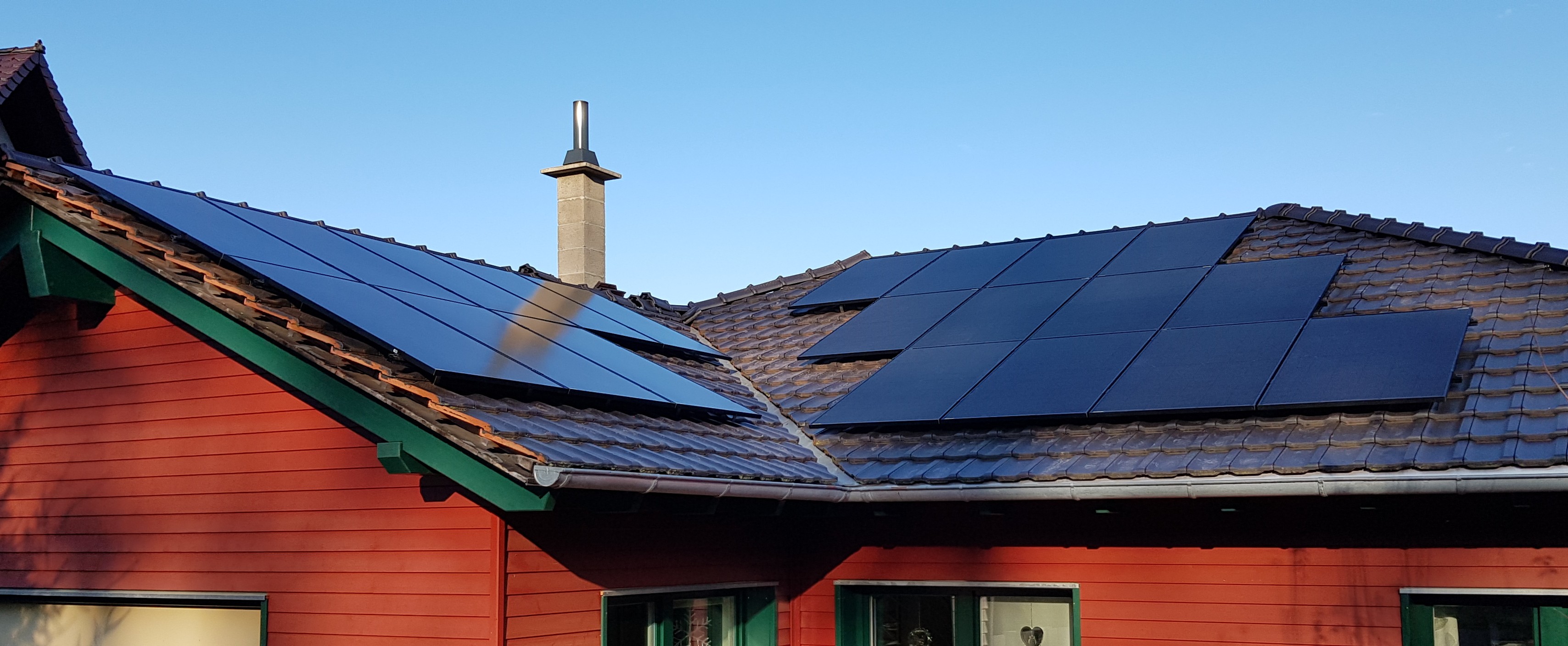 Photovoltaikanlage auf rotem Ziegeldach eines Wohnhauses